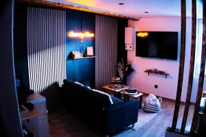 a living room with a couch and a flat screen tv at CocooningRoom - Tain L'hermitage in Tain-lʼHermitage
