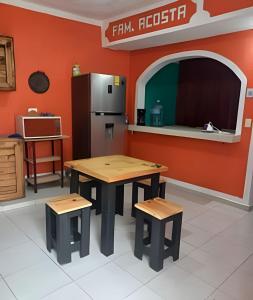 a kitchen with two tables and a refrigerator at Acosta 2 in San Lorenzo Tlalmimilolpan