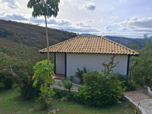 a small house with a roof on a hill at Chalé do vale in Lavras Novas