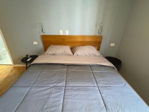 a bedroom with a large bed with a wooden headboard at Conforto e Praticidade Apartamento até 3 no Batel in Curitiba +8 photos