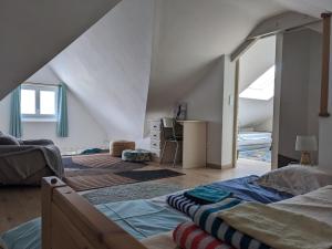 a bedroom with a bed and a room with an attic at Villa de 1926, plage de sable fin à 200m, proche commerces in Jullouville-les-Pins