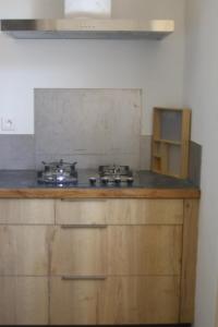 a kitchen with a stove top in a room at Villa de 1926, plage de sable fin à 200m, proche commerces in Jullouville-les-Pins
