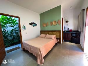 a bedroom with a bed and a green wall at Casa Naturaleza in Ilhabela