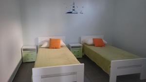 two beds with orange and green sheets in a room at Beautiful Apartment Jukic in Podstrana