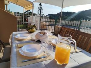 a table with plates and a pitcher of orange juice at Cactus Apartments - Sea View in Solanas +14 photos