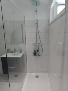 un bagno bianco con doccia e lavandino di Appartement Lilas a Saint-Père