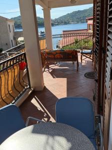 un balcon avec une table et des chaises et une vue sur l'eau dans l'établissement Green Sea Villa - Wild Orange Dubrovnik, à Zaton