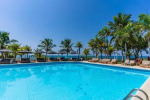 a swimming pool at a resort with palm trees at Hotel Cocoliso Island Resort in Isla Grande