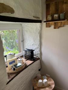 a kitchen with a table with cups and a window at Le Cabanon  +4 photos
