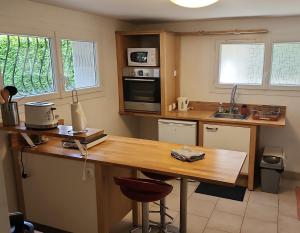 eine Küche mit einem Holztisch und einer Arbeitsplatte in der Unterkunft Charmant T2 avec terrasse jardin et parking privé, à 2 minutes du centre ville ! in Villeneuve-sur-Lot