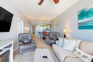 a living room with a couch and chairs and a tv at Harbor Cove #410 in Orange Beach