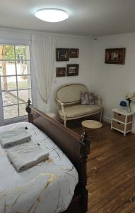 ein Schlafzimmer mit einem Bett, einem Stuhl und einem Fenster in der Unterkunft Charmant T2 avec terrasse jardin et parking privé, à 2 minutes du centre ville ! in Villeneuve-sur-Lot