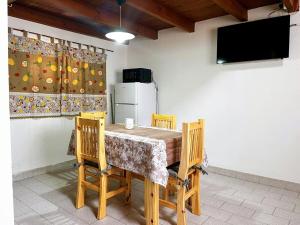 a dining room with a table and chairs and a television at Genoveva, descanso y calma in Neuquén
