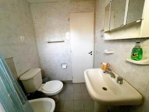 a white bathroom with a toilet and a sink at Genoveva, descanso y calma in Neuquén +20 photos