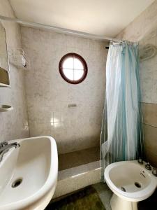 a bathroom with a sink and a toilet and a window at Genoveva, descanso y calma in Neuquén