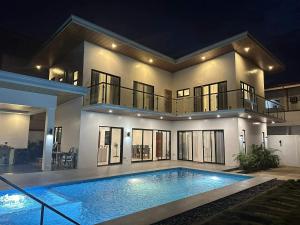 a large house with a swimming pool in front of it at Villa Bella in Puerto Princesa City +17 photos