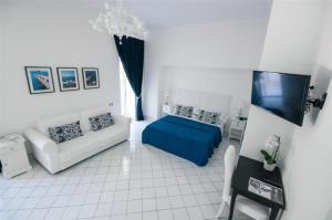 ein Wohnzimmer mit Sofa und Fernseher in der Unterkunft Palazzo Dogana Rooms in Agropoli