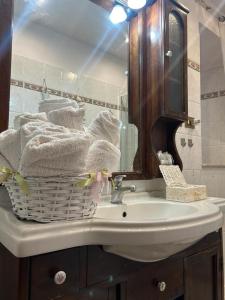 un lavandino in bagno con un cesto di asciugamani di La casa dei 4 venti a Civitavecchia Altre 7 foto