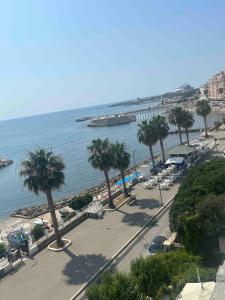 una vista di una spiaggia con palme e l'oceano di La casa dei 4 venti a Civitavecchia