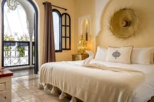 una camera da letto con un letto grande con una grande finestra di Riad Come & Va Medina a Marrakech Altre 109 foto