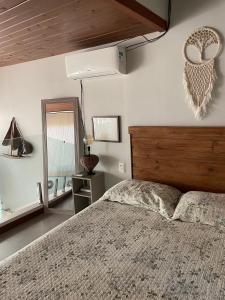 a bedroom with a large bed and a mirror at The Private Forest Lake Tinys Aruanda in Mata de Sao Joao