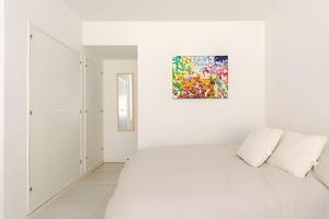 a white room with a bed and a painting on the wall at Escapada ideal a Mar del Plata luz, diseño y ubicación perfecta in Mar del Plata +38 photos