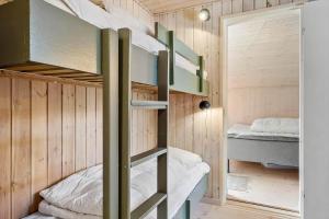 a bedroom with bunk beds in a tiny house at OH185-Hadsund-Sommerland-39 in Hadsund