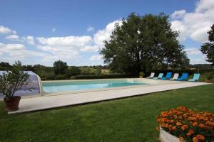 una piscina con sillas azules en un patio en Le Moulin du Cluzeau, en Thollet