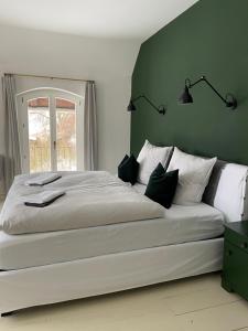 a bedroom with a large white bed with a window at Design Villa Uckermark mit riesigem Garten in Ferdinandshof