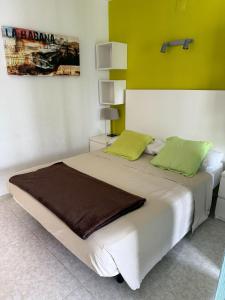 a bedroom with a large white bed with green walls at 602 Cala Forn Salou Side sea views w Direct access to the beach in Salou +29 photos