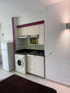 a kitchen with a washing machine and a microwave at 602 Cala Forn Salou Side sea views w Direct access to the beach in Salou