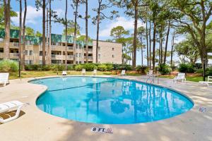 a large swimming pool with chairs and a building at Spa On Port Royal Sound 3337 in Hilton Head Island