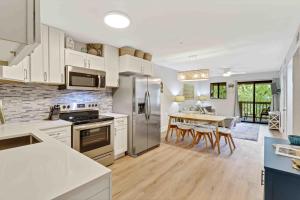 a kitchen with stainless steel appliances and a table with chairs at Spa On Port Royal Sound 3337 in Hilton Head Island