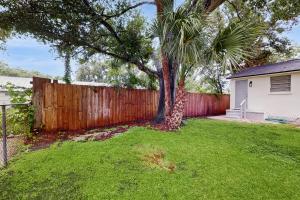 a palm tree in a yard next to a fence at Suite West B in Tampa
