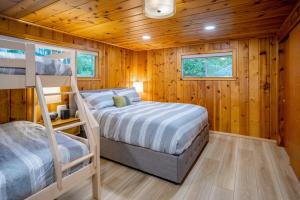 a bedroom with two bunk beds and wooden walls at Eagle Beach Retreat in Freeland