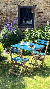 a picnic table and two chairs in a yard at "Le Cabanon" chambre d'hôte in Avioth