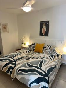 Un dormitorio con una cama con un edredón blanco y negro. en Pachi Beach Atlantic Garden Corralejo, en Corralejo