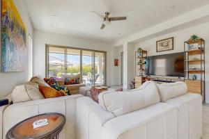 a living room with a white couch and a tv at Sundance Retreat in Rancho Mirage