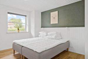 a bedroom with a bed with white sheets and a window at OH465-Hadsund-Havnovej-91 in Hadsund