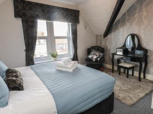 Un dormitorio con una cama con toallas. en The Causeway, en Llandudno