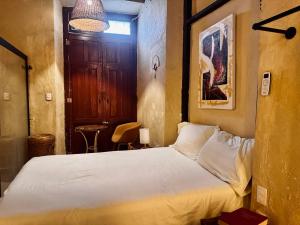 a bedroom with a white bed and a door at Casa Zapata, Campeche in Campeche