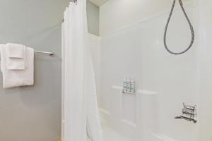 a shower with a white shower curtain in a bathroom at Tranquil Shores Hideaway in Cle Elum +17 photos