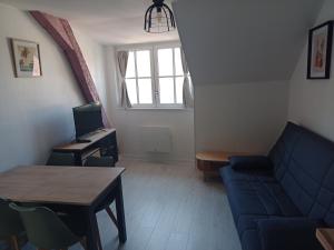 un soggiorno con divano e scrivania con computer di Appartement Lilas a Saint-Père