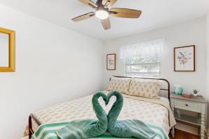 a bedroom with a bed with a heart towel on it at Suite West A in Tampa