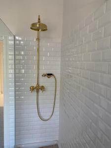 a shower in a bathroom with white tiles at Design Villa Uckermark mit riesigem Garten in Ferdinandshof +25 photos
