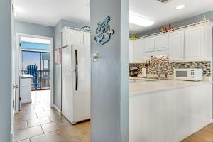 una cucina con mobili bianchi e un frigorifero di Ocean Reef 602 a Gulf Shores