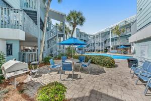 un patio con sedie e un tavolo con un ombrellone di Ocean Reef 602 a Gulf Shores