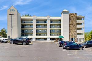 Un estacionamiento con autos estacionados frente a un edificio. en Laurel Inn Condominiums - Gatlinburg Getaway, en Gatlinburg