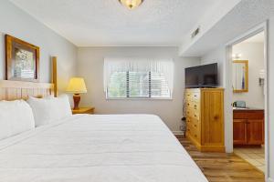 Un dormitorio con una gran cama blanca y un televisor. en Laurel Inn Condominiums - Gatlinburg Getaway, en Gatlinburg
