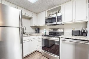 a kitchen with white cabinets and a stainless steel refrigerator at River Hideout in Pigeon Forge +14 photos